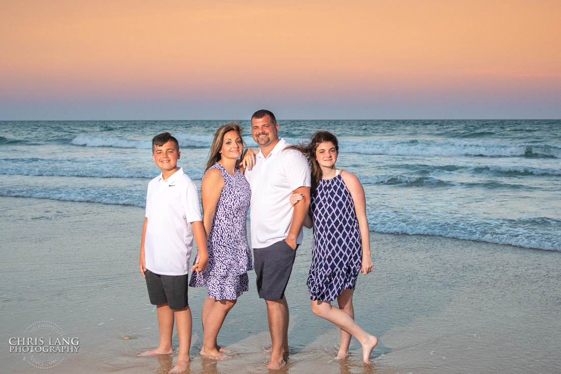  Family posinfg for sunset picture at the beach -Topsail Island Photography - Topsail Island NC Photographers - Chris Lang Photography -  Beach Photography - Family Photographer - Family photo - Beach Photographer - Beach Portraits -  Coastal Lifestyle Photography
