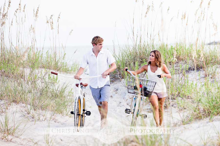 Image of couple walking bikes on the beach