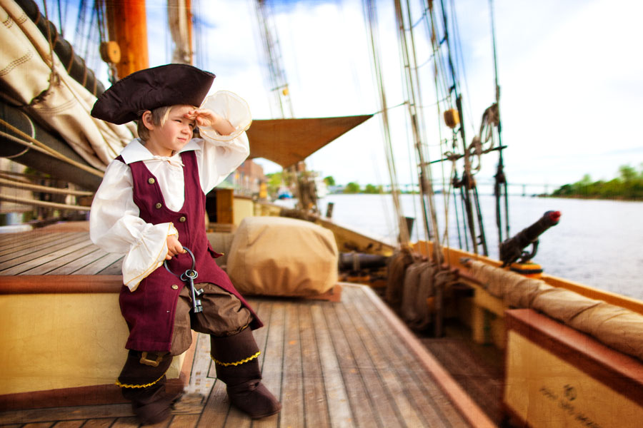 Image of young boy dressed as a pirate on vntage wooden ship -  Wilmington NC Kid - child Portrait Photographer - child porait photography - kids picture - photo ideas - chris lang photography