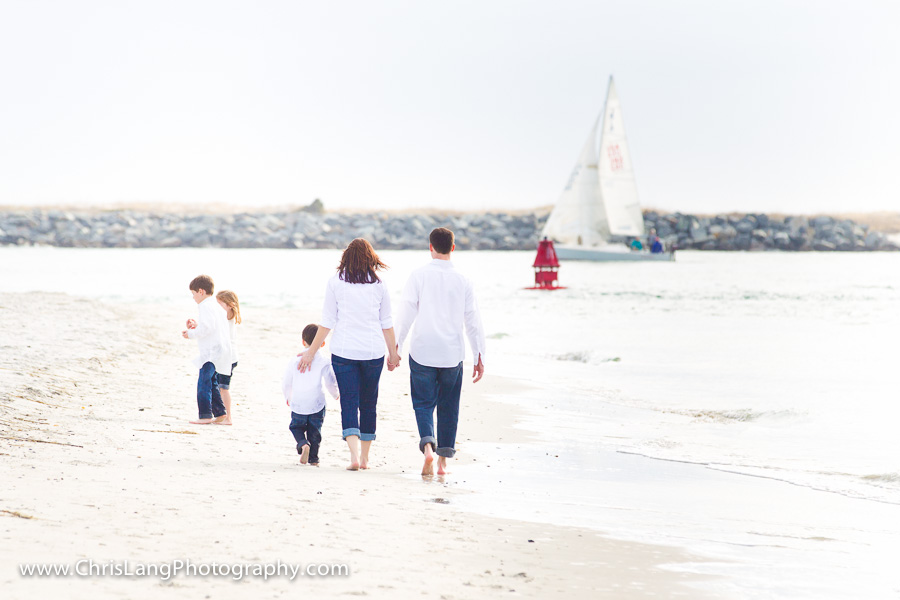 A family walking on the beach during family photography session in Wilmington NC