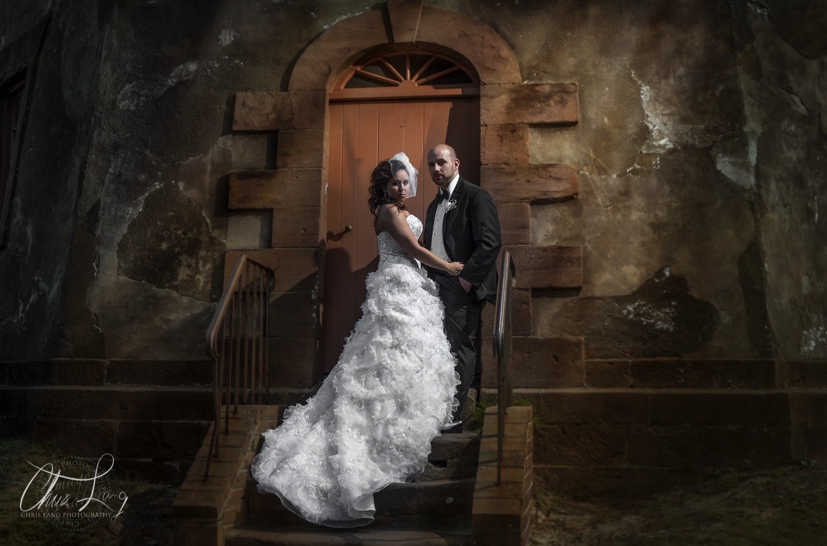 Bride and groom in front of old baldy white house on bald head island